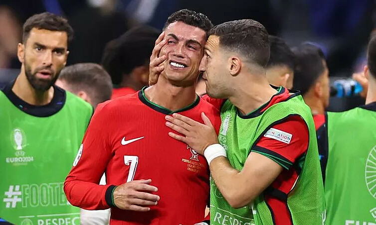 Diogo Dalot khích lệ Cristiano Ronaldo khi thủ quân Bồ Đào Nha khóc giữa hiệp phụ trận thắng Slovenia ở vòng 1/8 Euro trên sân Wald, thành phố Frankfurt, Đức tối 1/7/2024. Ảnh: Daily Star